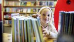 Leseglad: Tori Torbjørnsen (7) er dotter til biblioteksjef Silje Vågen Torbjørnsen. Ho har arva interessa for bøker, og har lese såpass mykje at ho har gjort seg fortent til tre premiar på biblioteket denne sommaren. Foto: Marius Knutsen/Sunnhordland